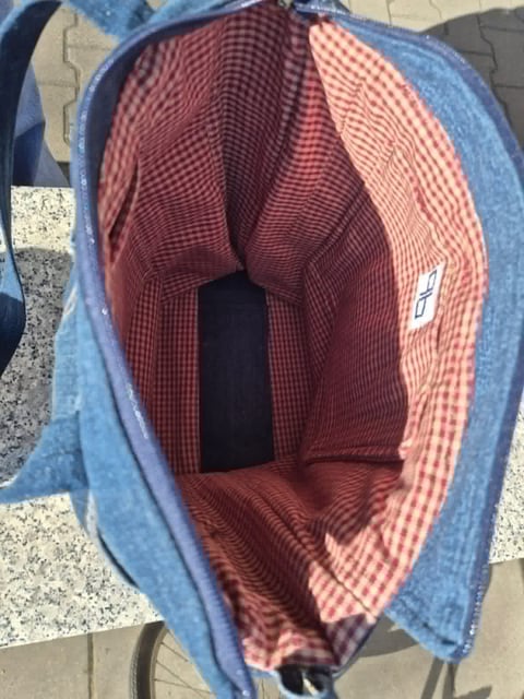 Interior view of a blue denim bucket hat with red and white checkered fabric lining